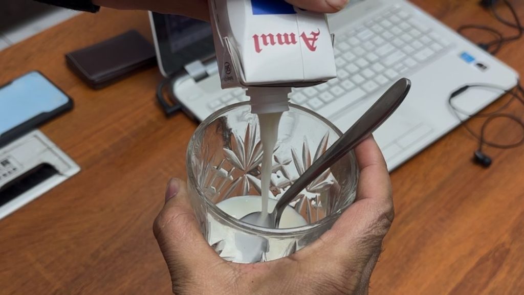 Abhishek Chauhan has emptied the Amul lassi into a glass.