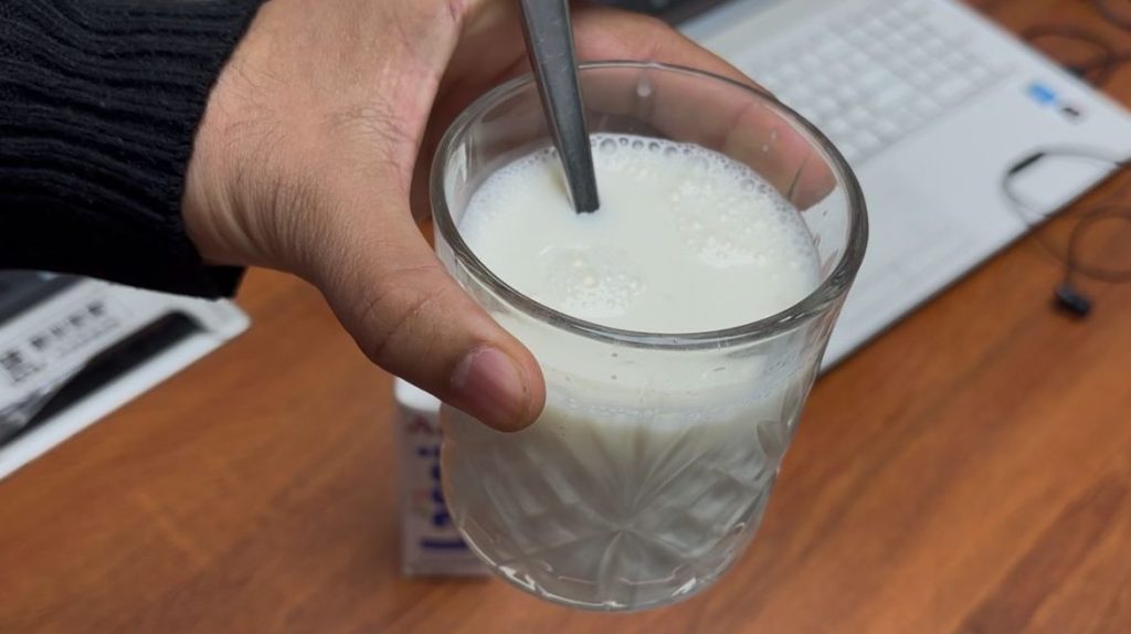 Abhishek Chauhan has emptied the Amul lassi into the glass. Now the glass contains the lassi with its original consistency.