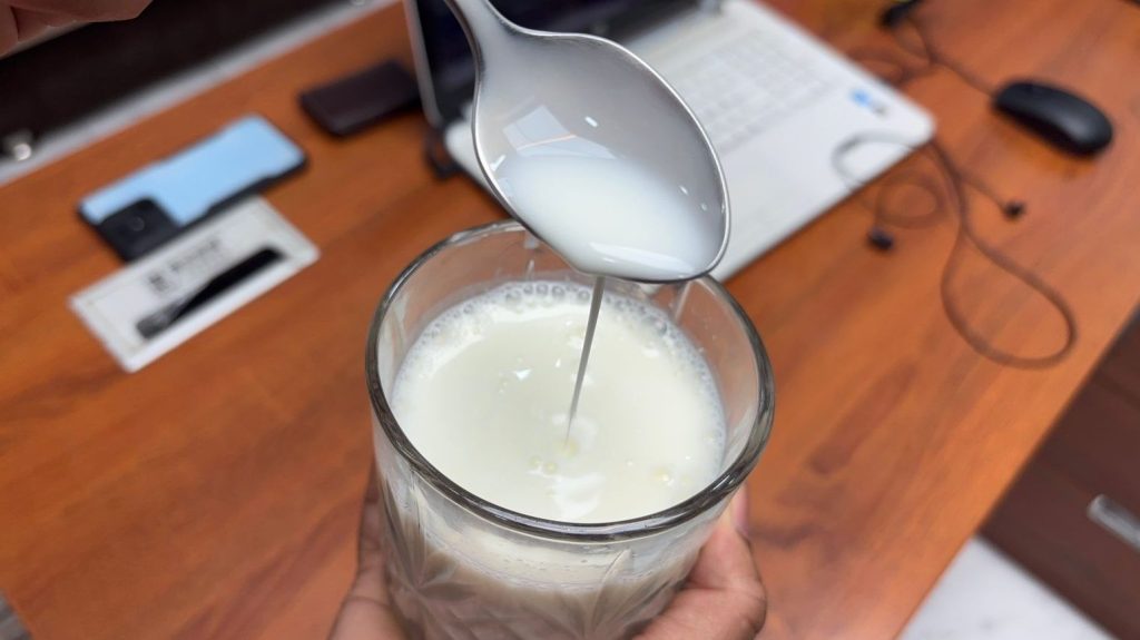 Abhishek Chauhan has emptied the Amul lassi into the glass. Now the glass contains the lassi with its original consistency.