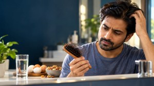 Adult checking hair shedding while concerned about vitamin deficiency-related hair loss